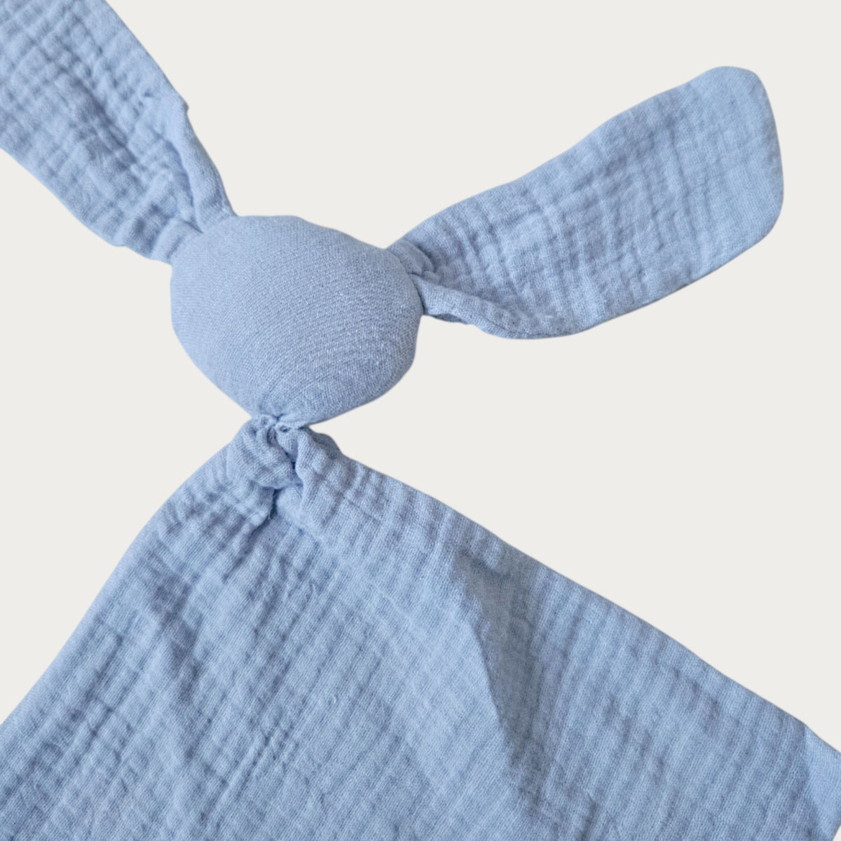 Sky blue muslin bunny security blanket with long ears, round head and squared body. Little Scandi baby Close Up