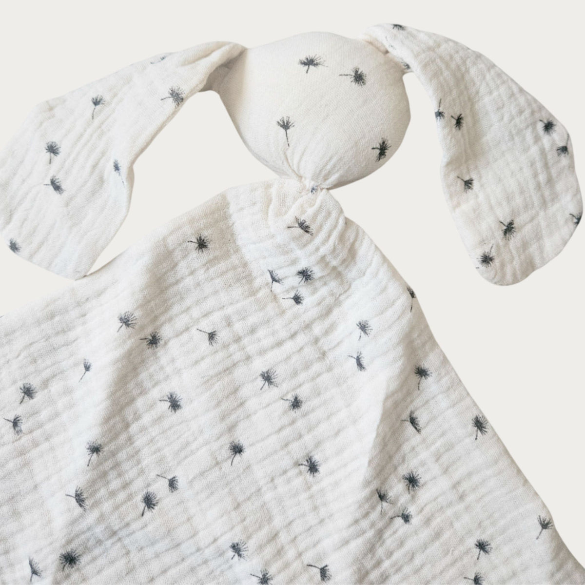 Cream bunny comforter blanket with black dandelion pattern design with a round head and squared body and two long ears